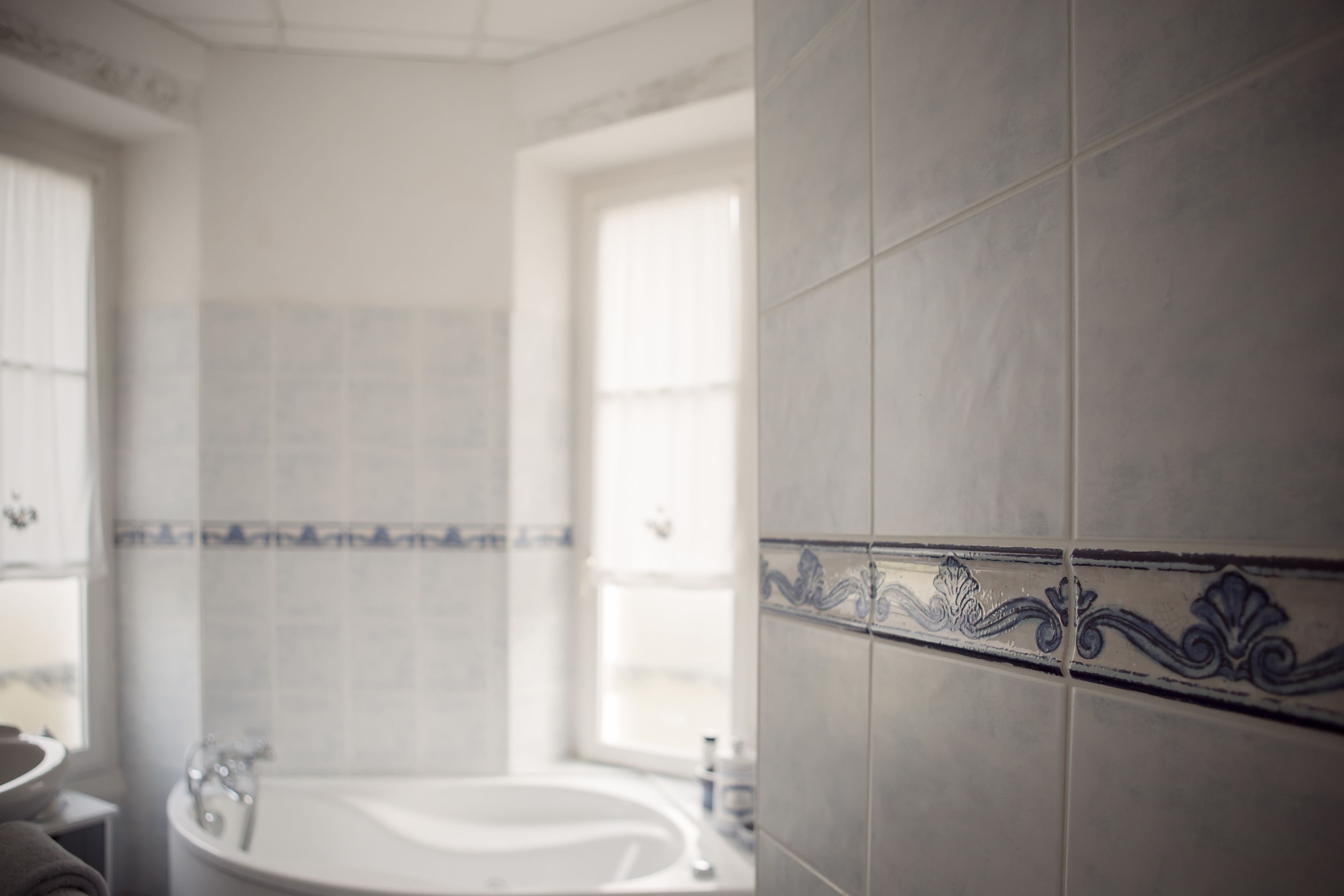 A bathroom with a bathtub, a sink, and a window.