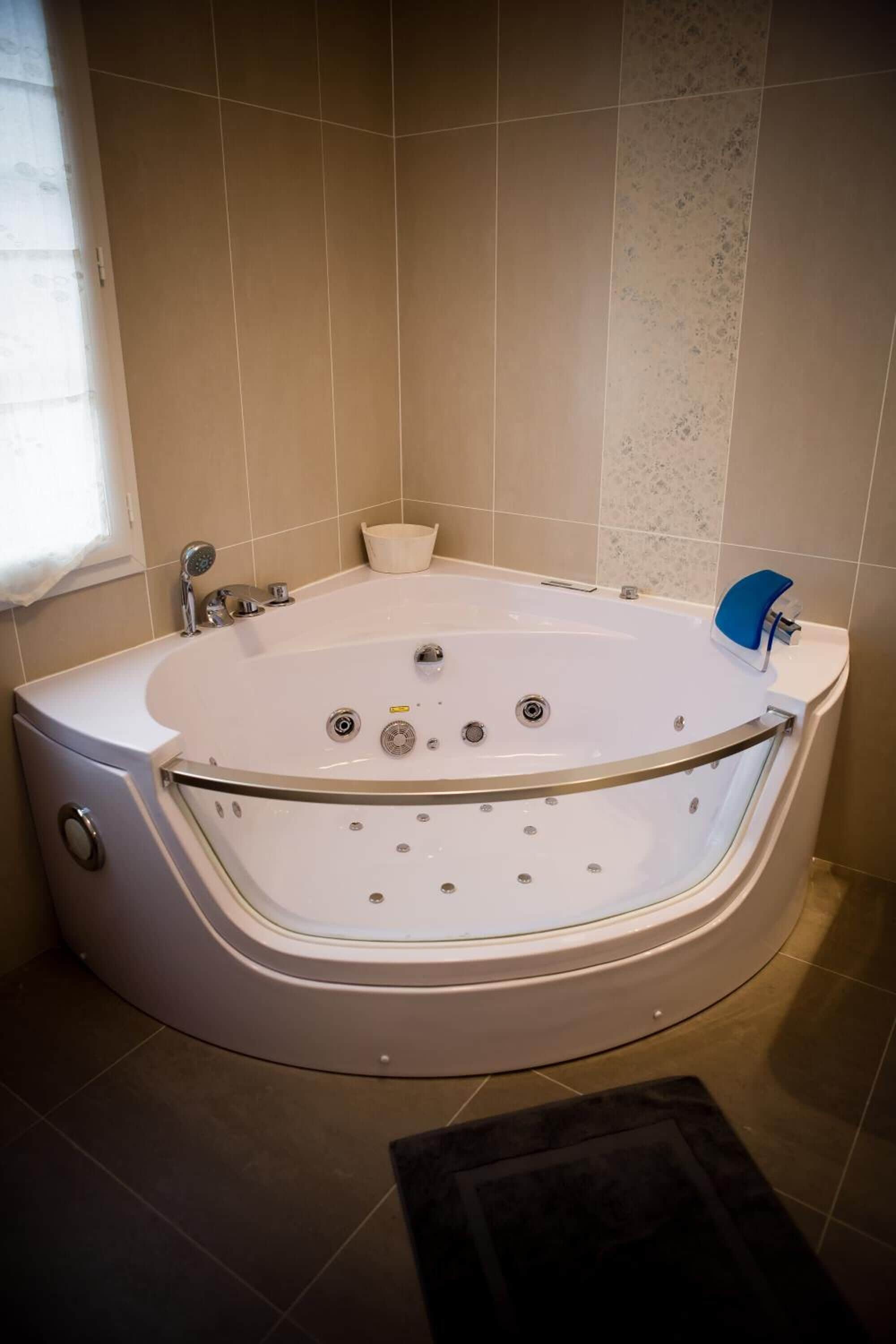 Un baño moderno con una bañera independiente, un ventanal y un perchero para toallas.