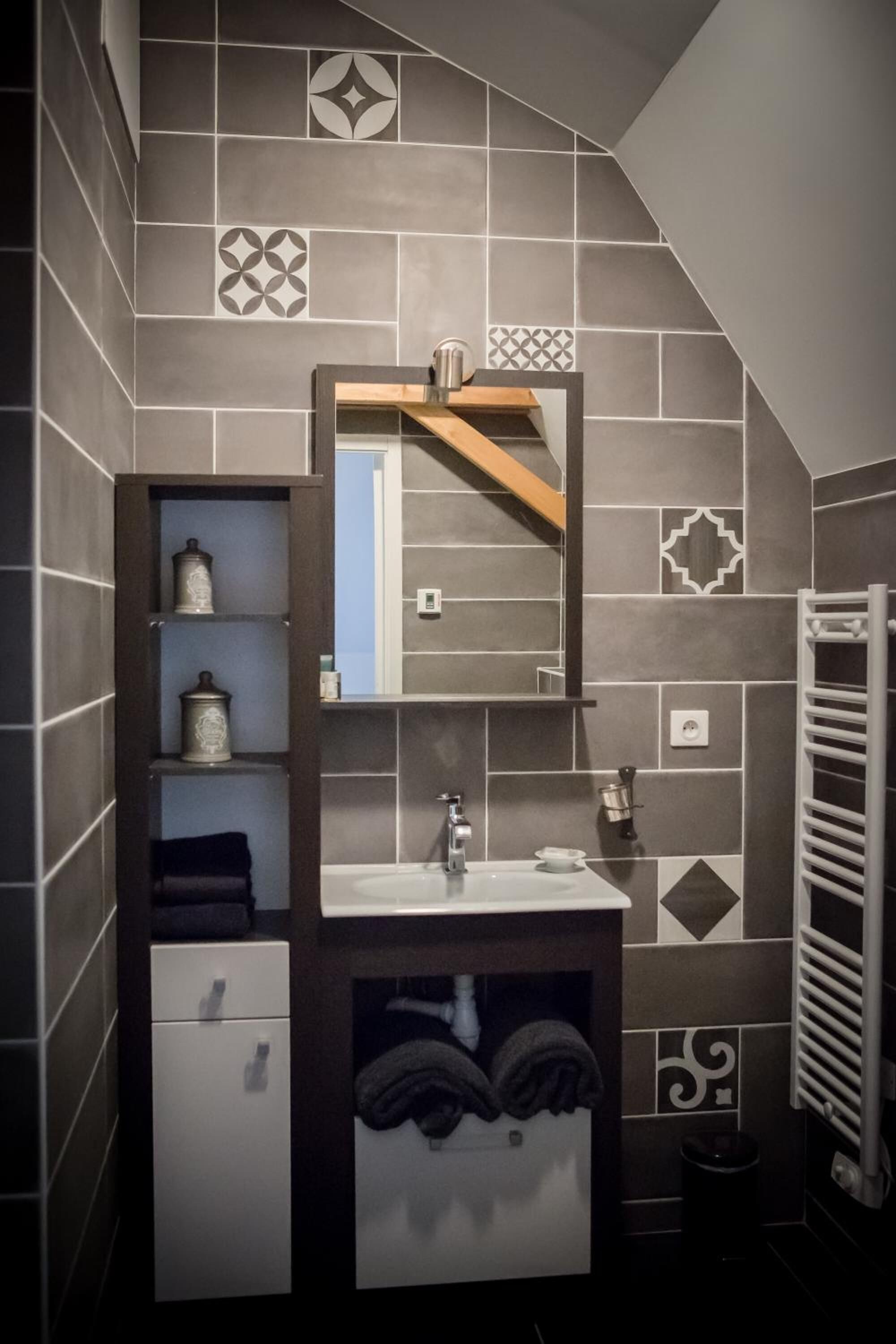 Un baño de diseño moderno, con lavamanos integrado, espejo y perchero.