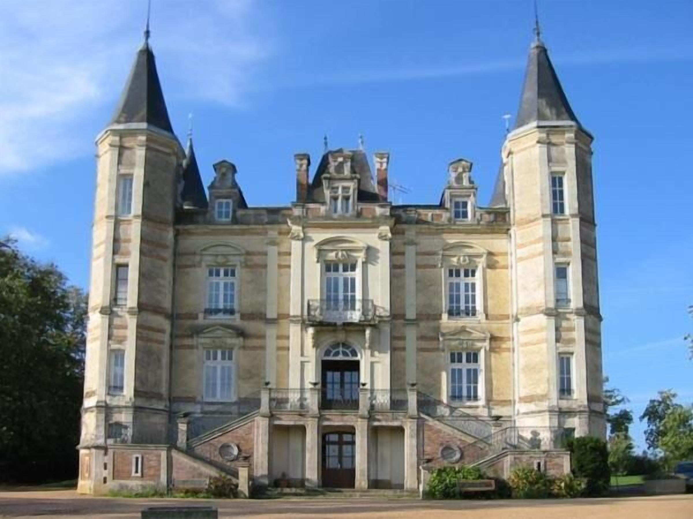 A large, historic building with a symmetrical facade, multiple windows, and two prominent towers.