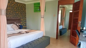 Quarto com cama, mesa de cabeceira e um banquinho.