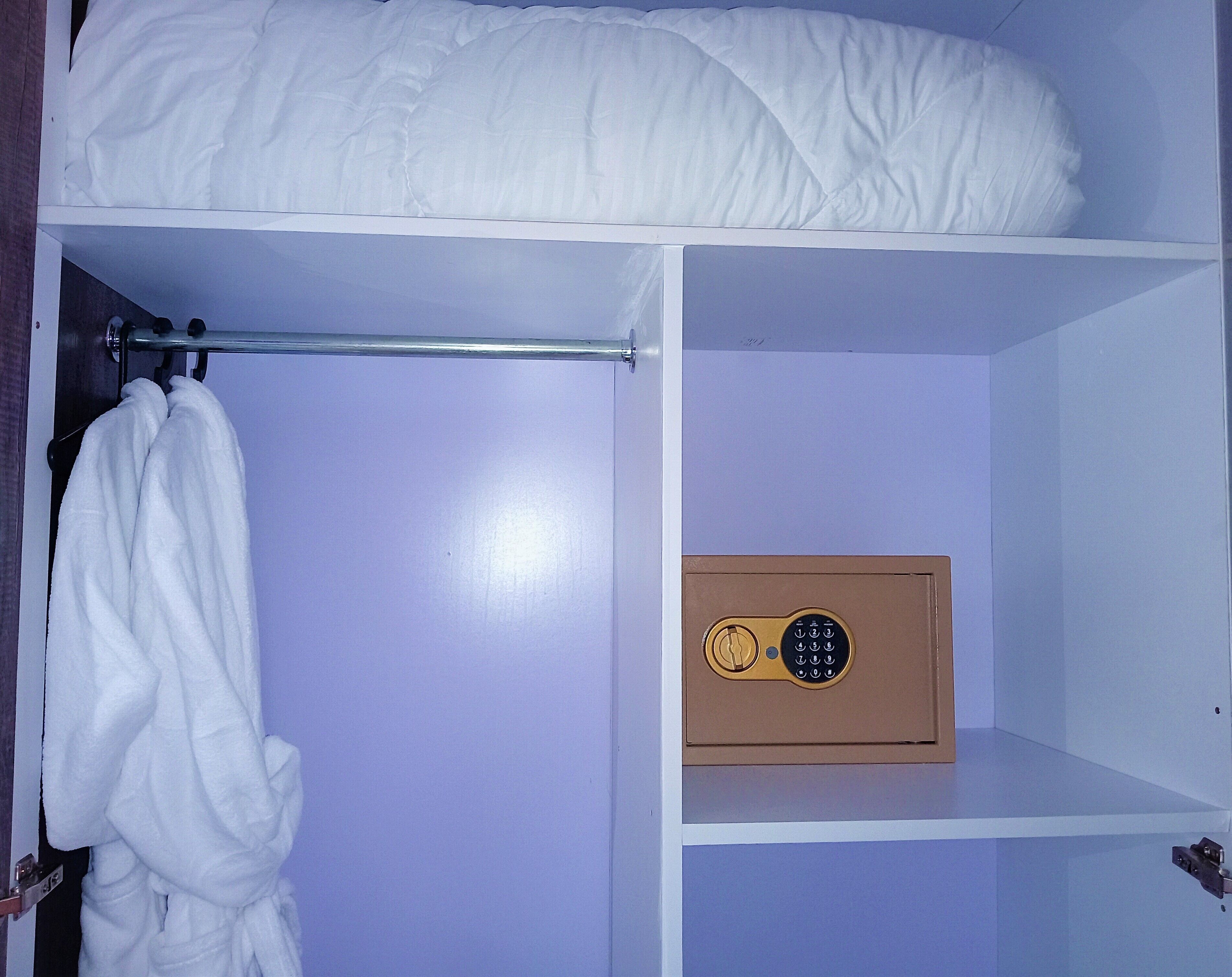 A room with a bunk bed, a towel hanging on a rack, and a safe.