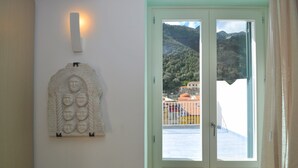 A room with a white door and a view of a mountain landscape. - Casa Mao (Amalfi)