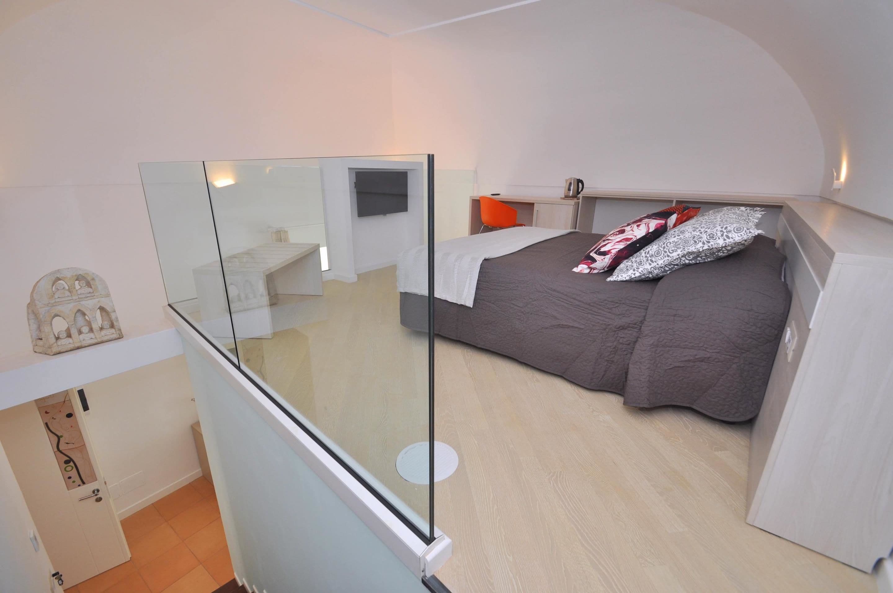 A bedroom with a bed, a desk, and a chair.