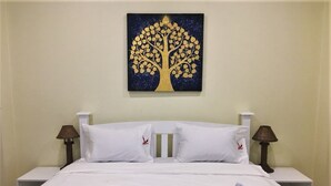 A hotel room with a bed, white bedding, two pillows, two bedside tables with lamps, and a wall-mounted painting of a tree. - Kristi House (Chiang Mai)