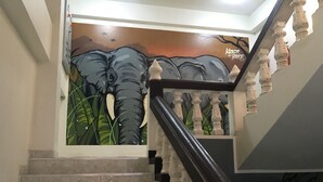 A staircase with a mural of an elephant and trees, and the name 'Kristi House' on the wall. - Kristi House (Chiang Mai)