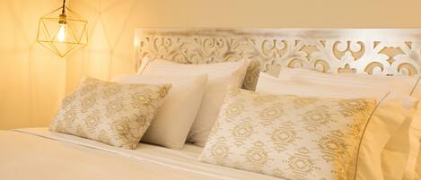 A bed with a white headboard and patterned pillows.