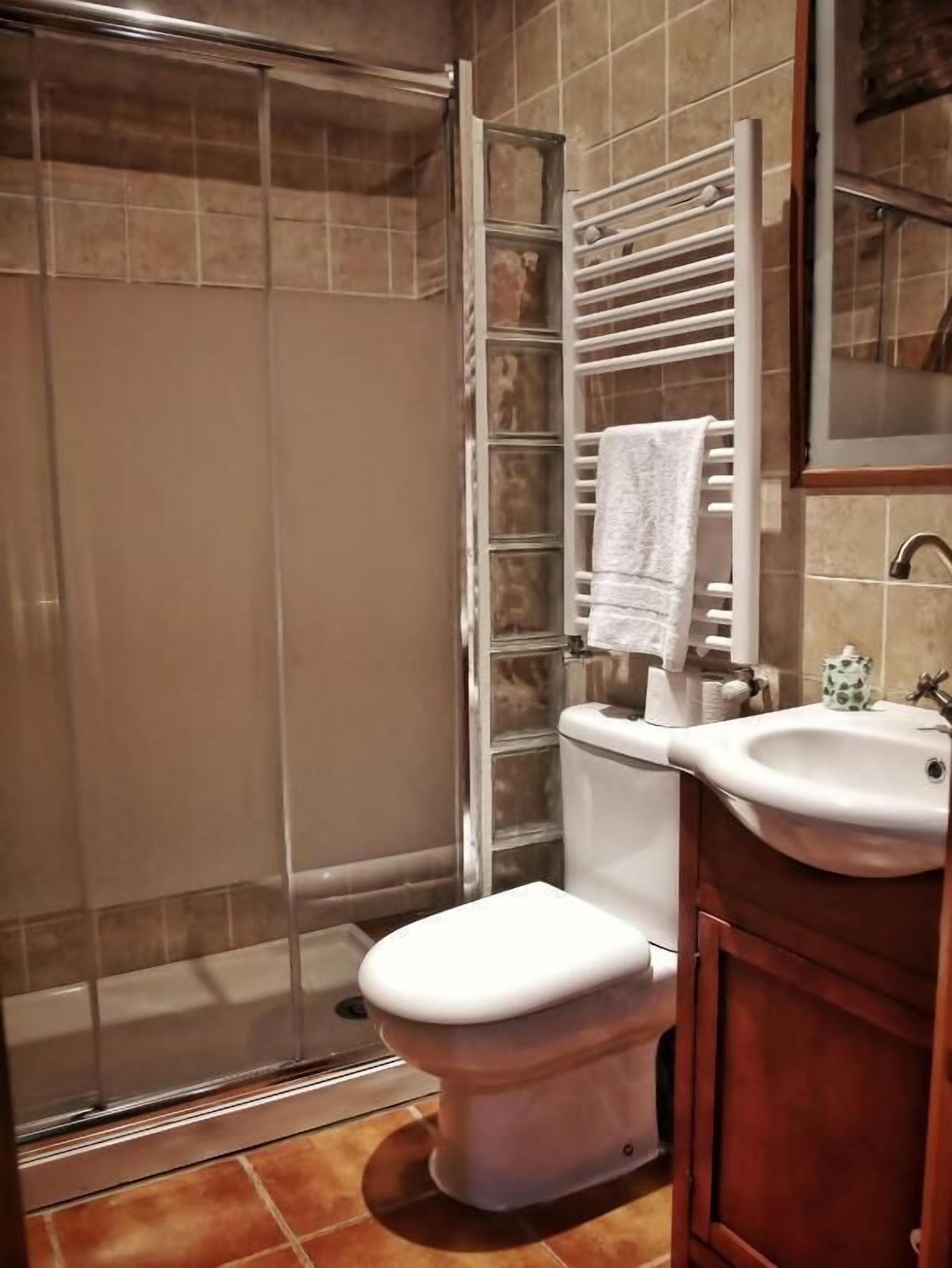 Un baño con ducha, inodoro y lavamanos.
