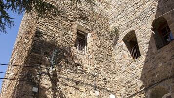 A stone building with a large arched entrance and multiple windows.