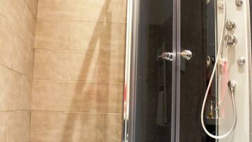 A bathroom with a glass-enclosed shower, a toilet, and a bathtub.