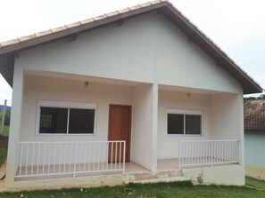 A two-story house with a balcony on the ground floor and a door on the upper floor. - Pousada Leolud (Socorro)