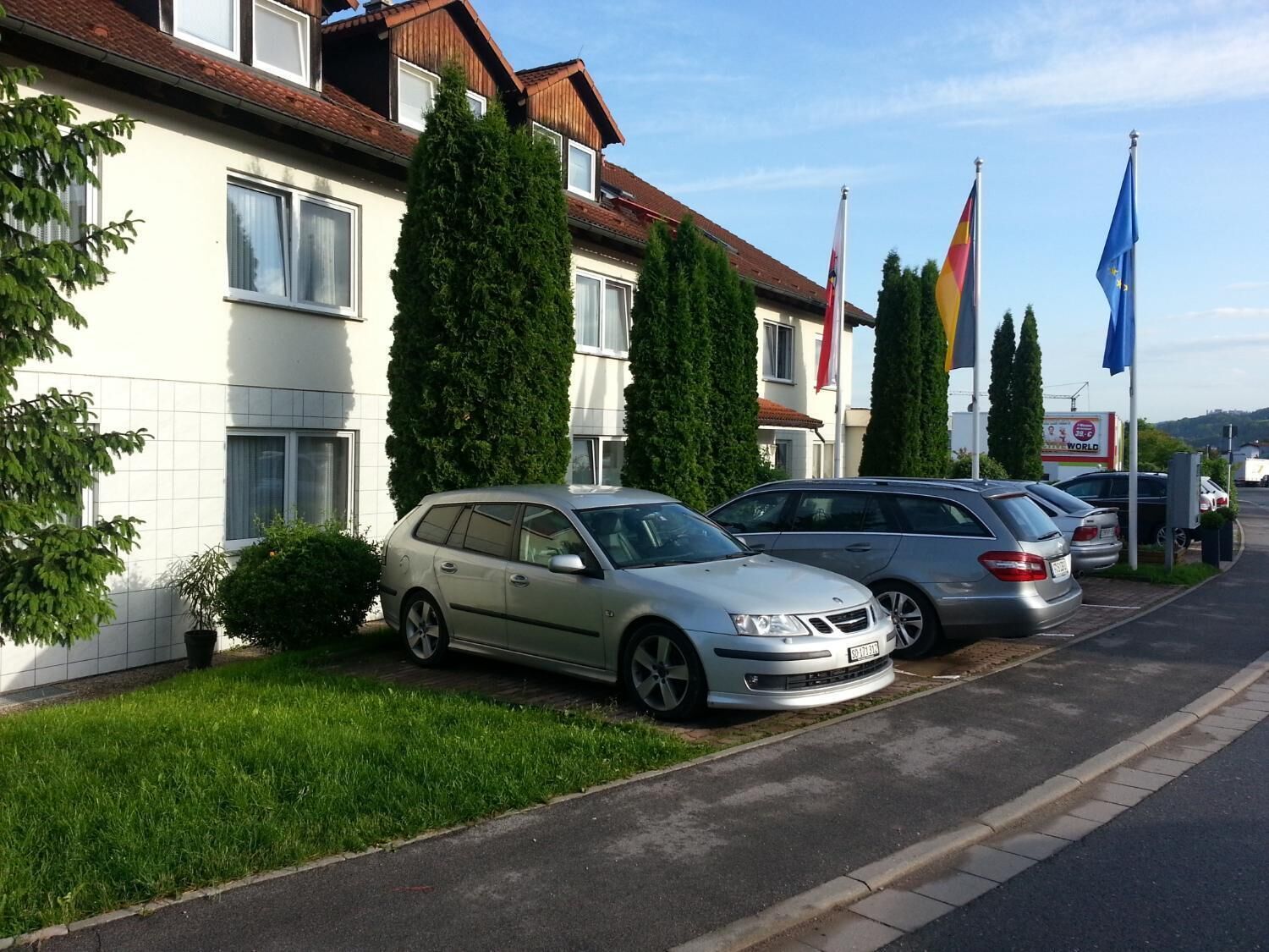 A row of two-story houses with parked cars in front.