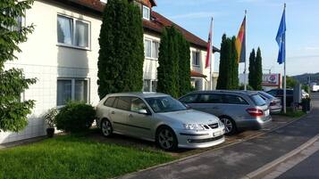 A row of two-story houses with parked cars in front.