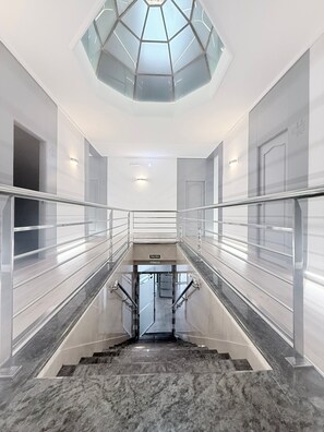 A modern interior with a glass ceiling, a central staircase, and a sign reading 'SALIDA'. - Hotel Las Canteras (Santa Cruz de Mudela)