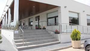 Ein modernes Gebäude mit einem Schild, auf dem 'HOTEL' steht, und einer Treppe, die zu einem Eingang führt.