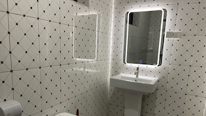 Une salle de bain avec des toilettes, un lavabo et un miroir.