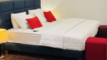 Deluxe Room, 1 Bedroom | Desk, laptop workspace, iron/ironing board, bed sheets