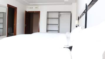 A hotel room with a bed, a wardrobe, and a mirror.