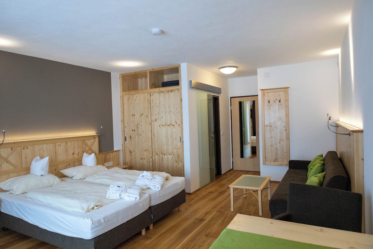 Un dormitorio con una cama grande, una mesita, un sofá y un armario.