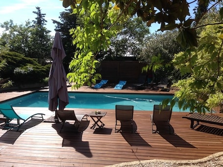 Una piscina al aire libre, sillones reclinables de piscina