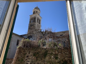 A view of a historic building with a tall tower and a stone wall. - Appartamenti St'Andrea (Levanto)