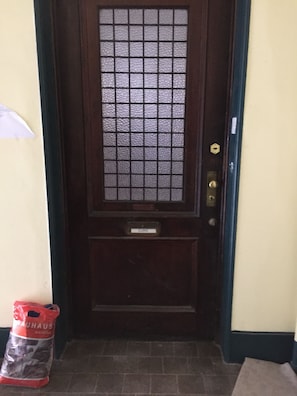A dark wooden door with a grid-patterned glass panel and a nameplate labeled "CURIC".