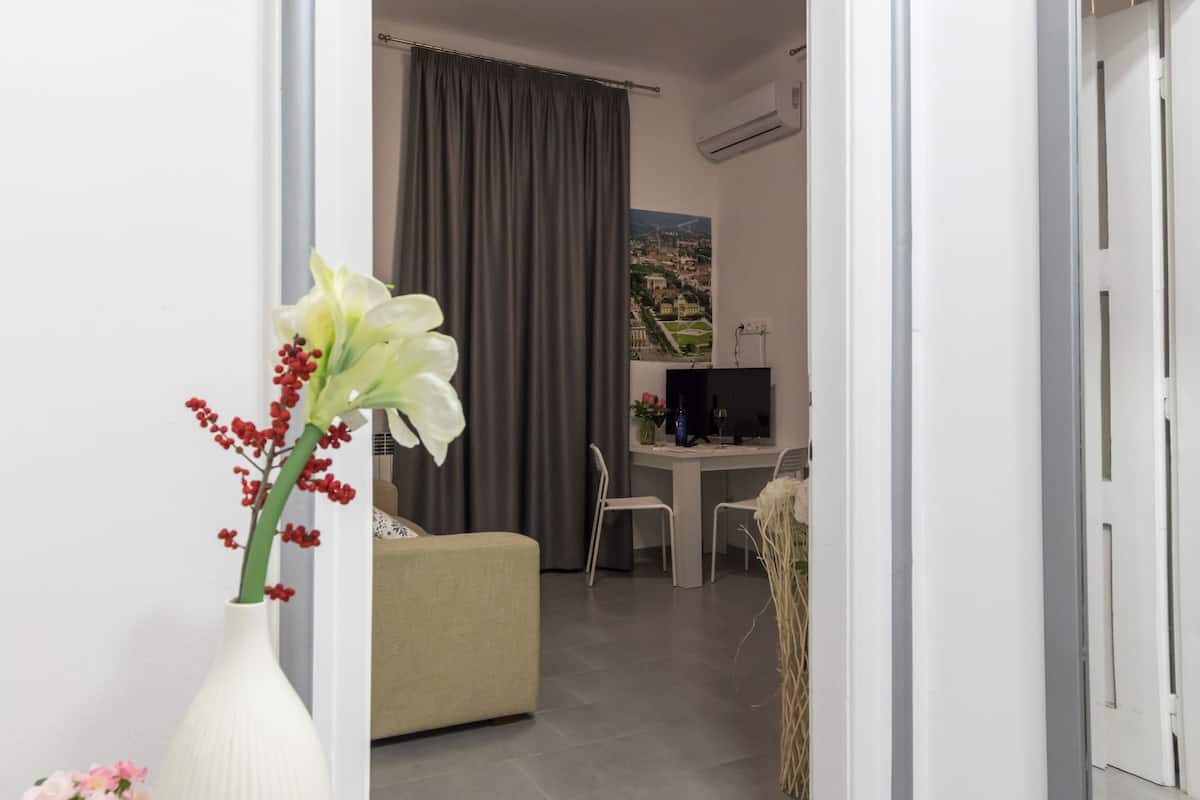 Een moderne hotelkamer met een houten bureau, een comfortabele bank en uitzicht op een stadsbeeld.