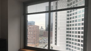 A room with a large window overlooking a cityscape. - Downtown Luxury Suites (Jersey City)