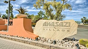 Ein großes Schild für Anasazi Village vor einer Wüstenlandschaft.