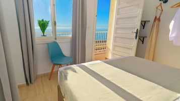 Habitación doble superior, vista a la playa | Tabla de planchar con plancha, wifi gratis y ropa de cama