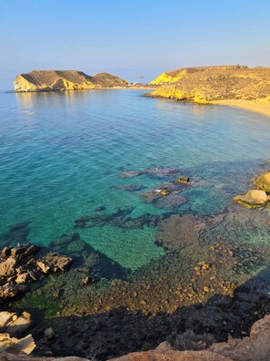 A coastal landscape with clear blue water, rocky shorelines, and distant hills. - Maxcaly Playa by Blossom Hotels (Aguilas)