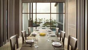 A dining area with a long table set for six, overlooking a landscaped garden. - Fairfield by Marriott Belitung (Tanjung Pandan)