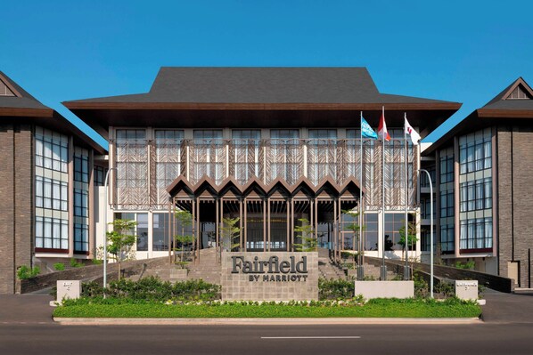 A Fairfield by Marriott hotel with a modern architectural design, featuring a prominent entrance with steps and a signboard.