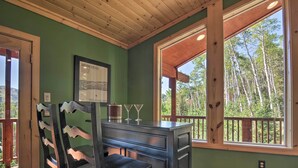 A room with a wooden ceiling, a green wall, a window with a view of trees, a framed picture on the wall, and a bar area with chairs and glasses. - < 1 Mi to Brian Head Resort: Mtn-View Gem w/ Deck (Brian Head)