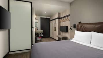 Une chambre d’hôtel moderne dotée d’un grand lit, d’une télévision à écran plat, d’un bureau avec une chaise et d’une armoire.