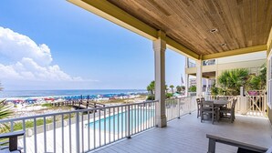 A wooden deck with a pool, overlooking a beach with umbrellas and a clear sky. - Gulf Front House in Orange Beach | Direct Beach Access | Pool | Sleeps 24 (Orange Beach)