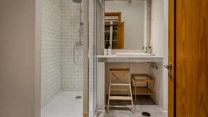 A bathroom with a shower, sink, and wooden step ladder. - Master Historical Gem in Chiado (Lisboa)