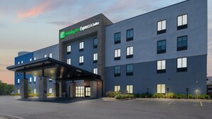 Ein Holiday Inn Express & Suites Gebäude mit modernem Design, mit einem Flachdach, großen Fenstern und einem überdachten Eingangsbereich.