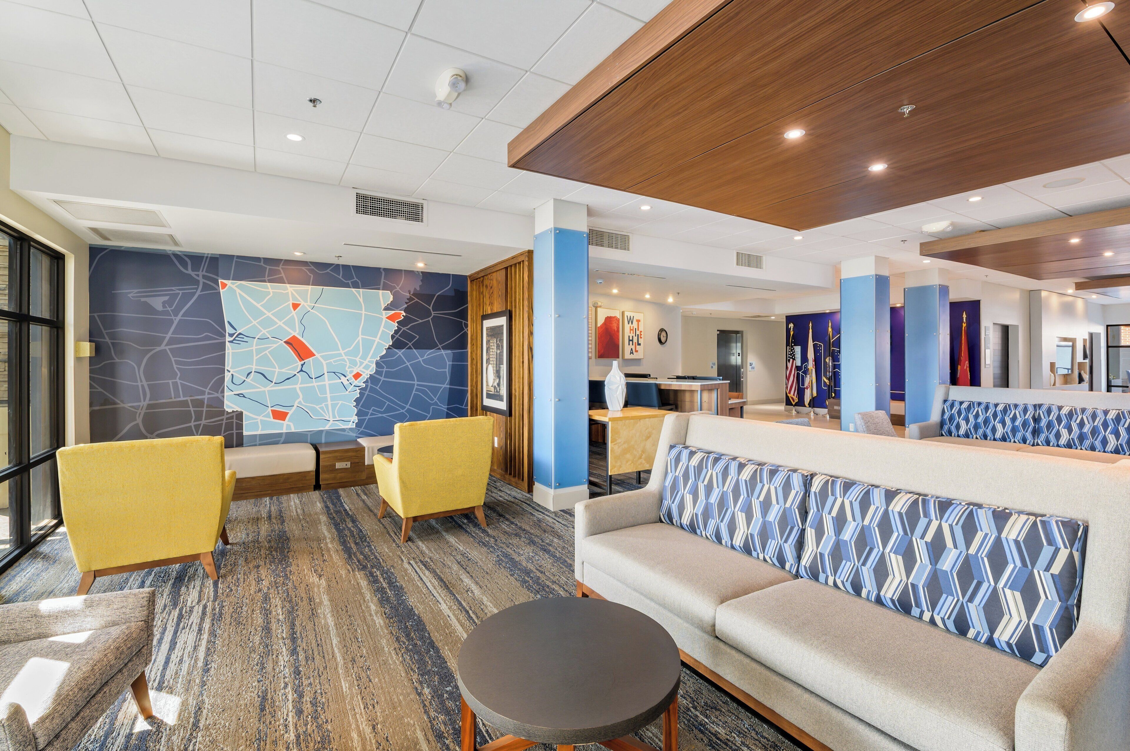 A modern lobby with a map mural, seating areas, and a reception desk.
