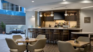 Una cocina moderna con barra, capacidad para 8 personas y un amplio ventanal con vistas al espacio.