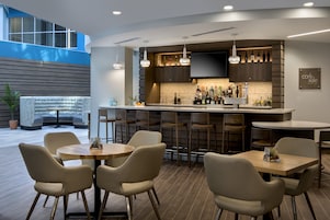 Una cocina moderna con barra, capacidad para 8 personas y un amplio ventanal con vistas al espacio.