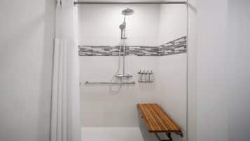 A shower with a rain showerhead, a handheld showerhead, and a handheld shower attachment.