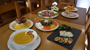 A dining table with various dishes including soup, salad, and grilled vegetables. - El Trasgu de Foncebadón (Santa Colomba de Somoza)