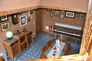 A room with a dining table, chairs, a globe, a clock, framed pictures, and a radiator. - El Trasgu de Foncebadón (Santa Colomba de Somoza)