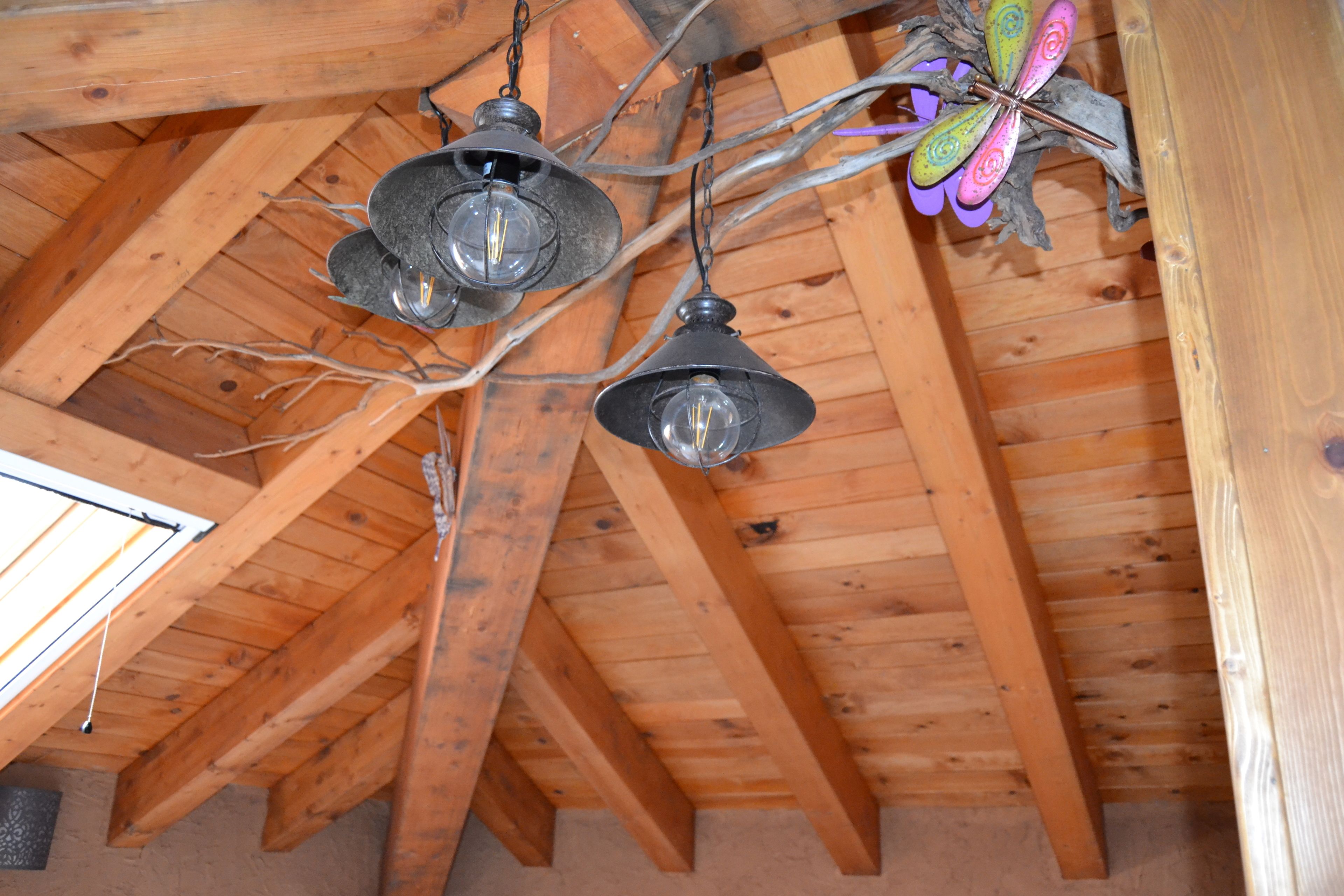 A wooden ceiling with exposed beams and hanging pendant lights.