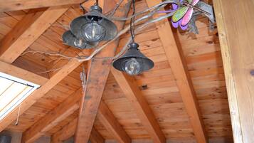 A wooden ceiling with exposed beams and hanging pendant lights.