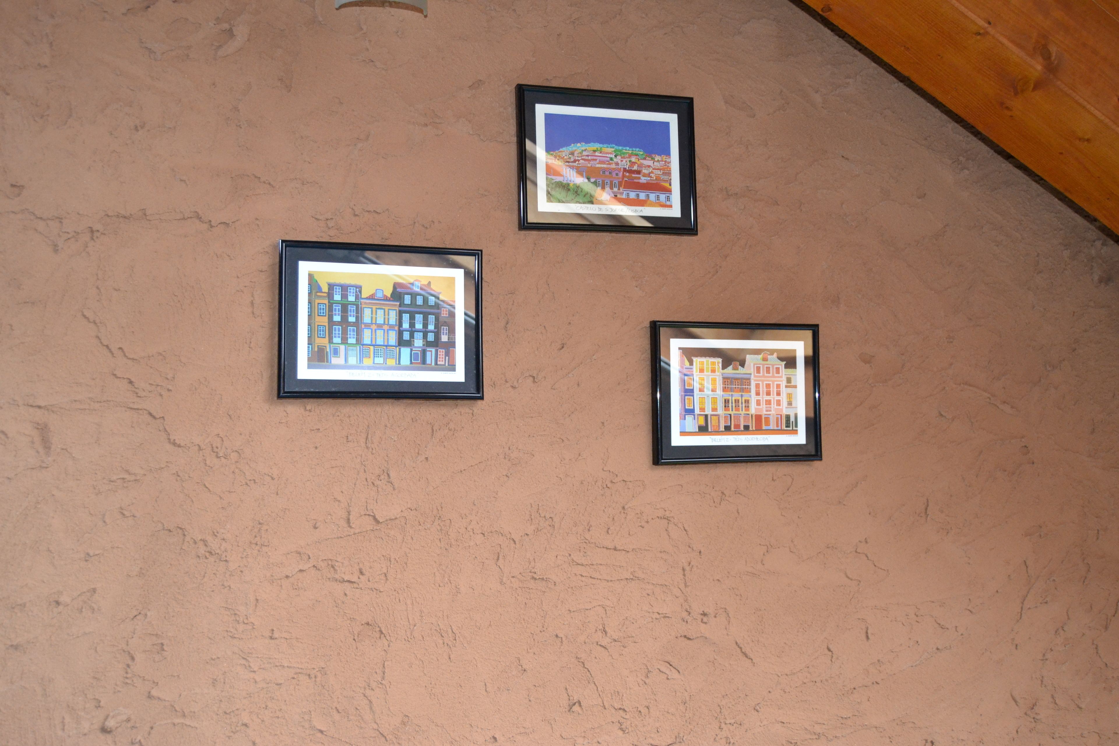 Tres cuadros con imágenes de edificios sobre una pared con textura.