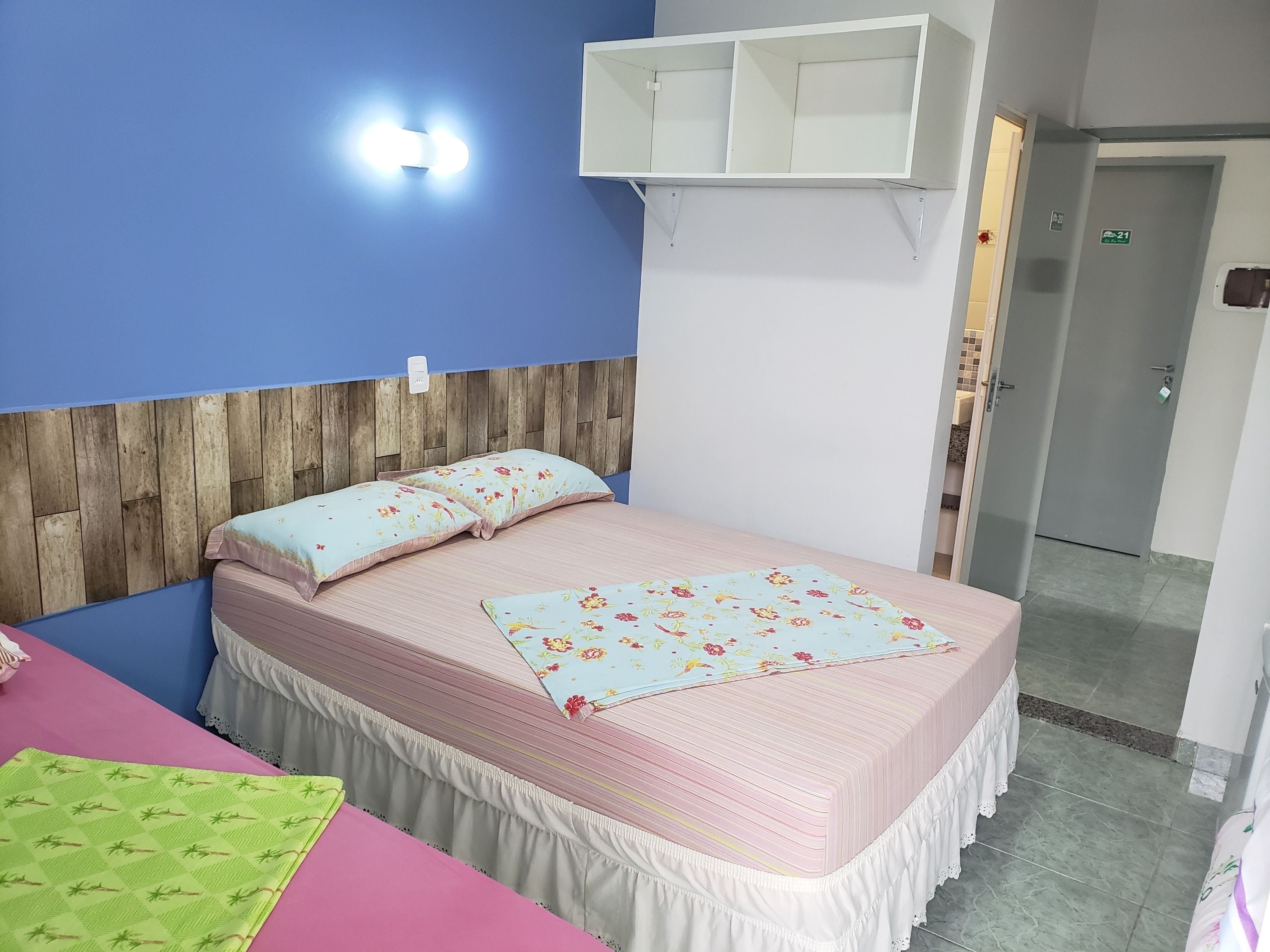 A bedroom with a bed, a nightstand, a dresser, a mirror, and a door.