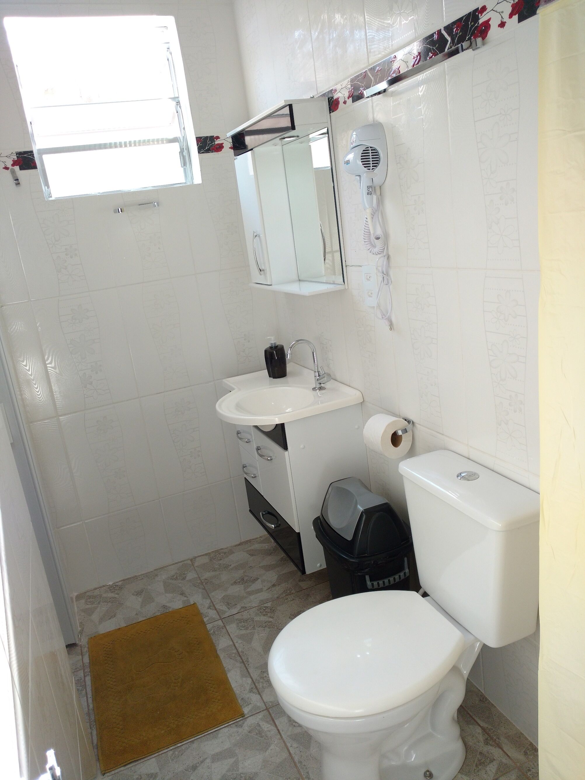 Ein Badezimmer mit Toilette, Waschbecken und Spiegel.