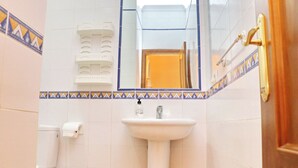 A bathroom with a white sink, a toilet, and a mirror. - Two bedroom apartment close to beaches (Conil de la Frontera)